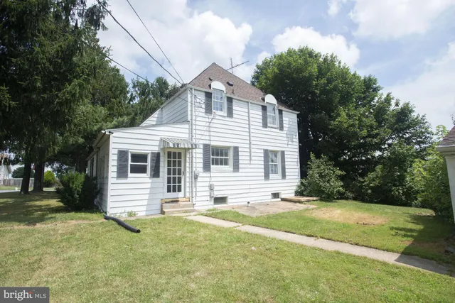 a view of a house with a yard and tree