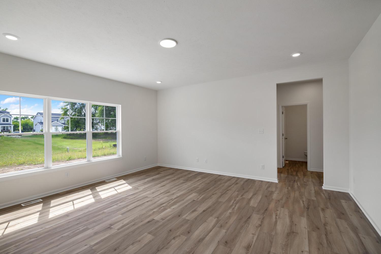 557 East 130th Lane Crown Point, IN 46307 - Photo 11 of 23 a view of an empty room with wooden floor and a window