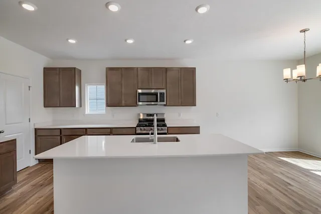 a kitchen with kitchen island a sink stainless steel appliances and cabinets