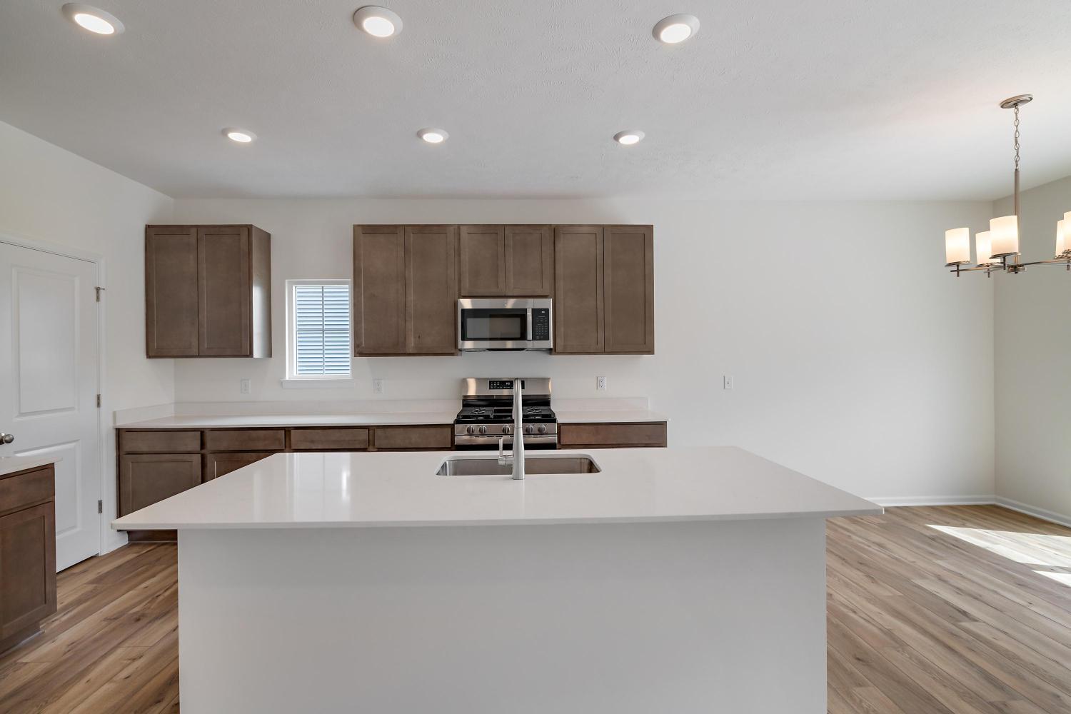 557 East 130th Lane Crown Point, IN 46307 - Photo 7 of 23 a kitchen with kitchen island a sink stainless steel appliances and cabinets