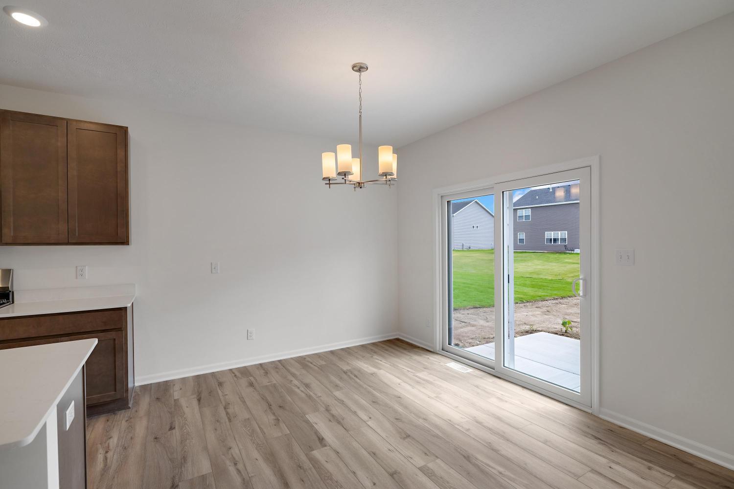 557 East 130th Lane Crown Point, IN 46307 - Photo 9 of 23 a view of an empty room with window and wooden floor