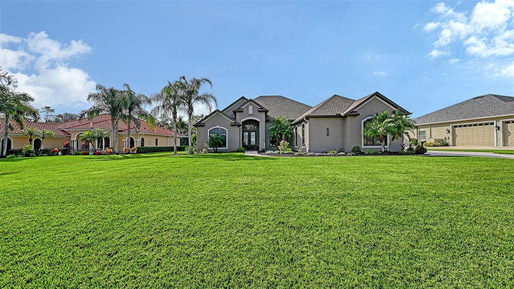 15425 Mulholland Road Parrish, FL 34219 - Photo 11 of 67 a view of a house with a big yard and large trees