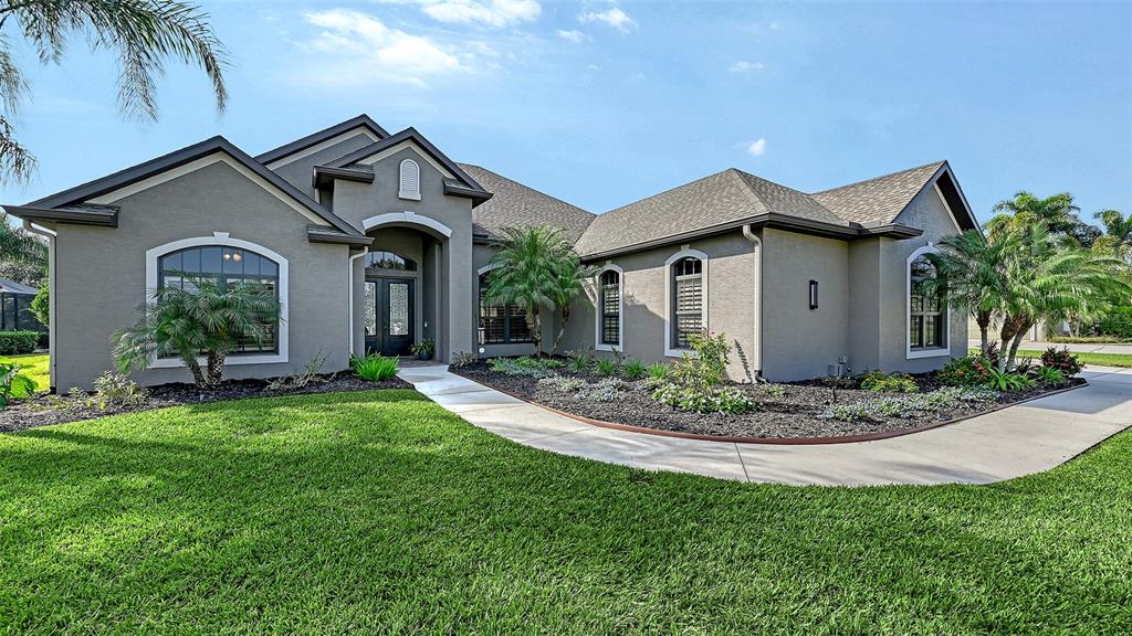 15425 Mulholland Road Parrish, FL 34219 - Photo 12 of 67 a front view of a house with a garden and plants