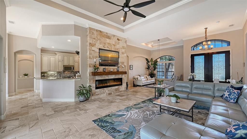 15425 Mulholland Road Parrish, FL 34219 - Photo 22 of 67 a living room with furniture a fireplace and a chandelier