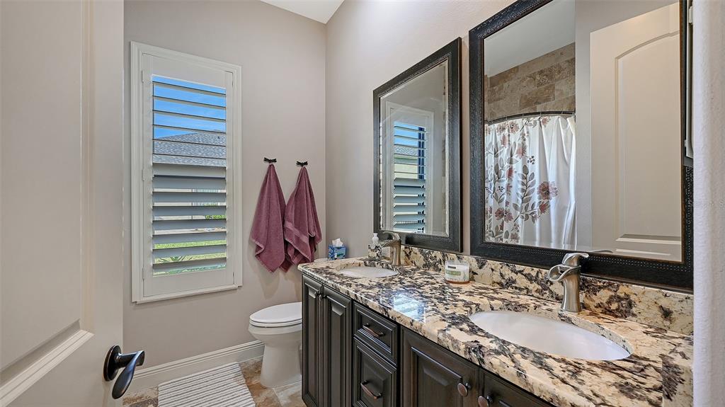 15425 Mulholland Road Parrish, FL 34219 - Photo 40 of 67 a bathroom with a granite countertop sink toilet and shower