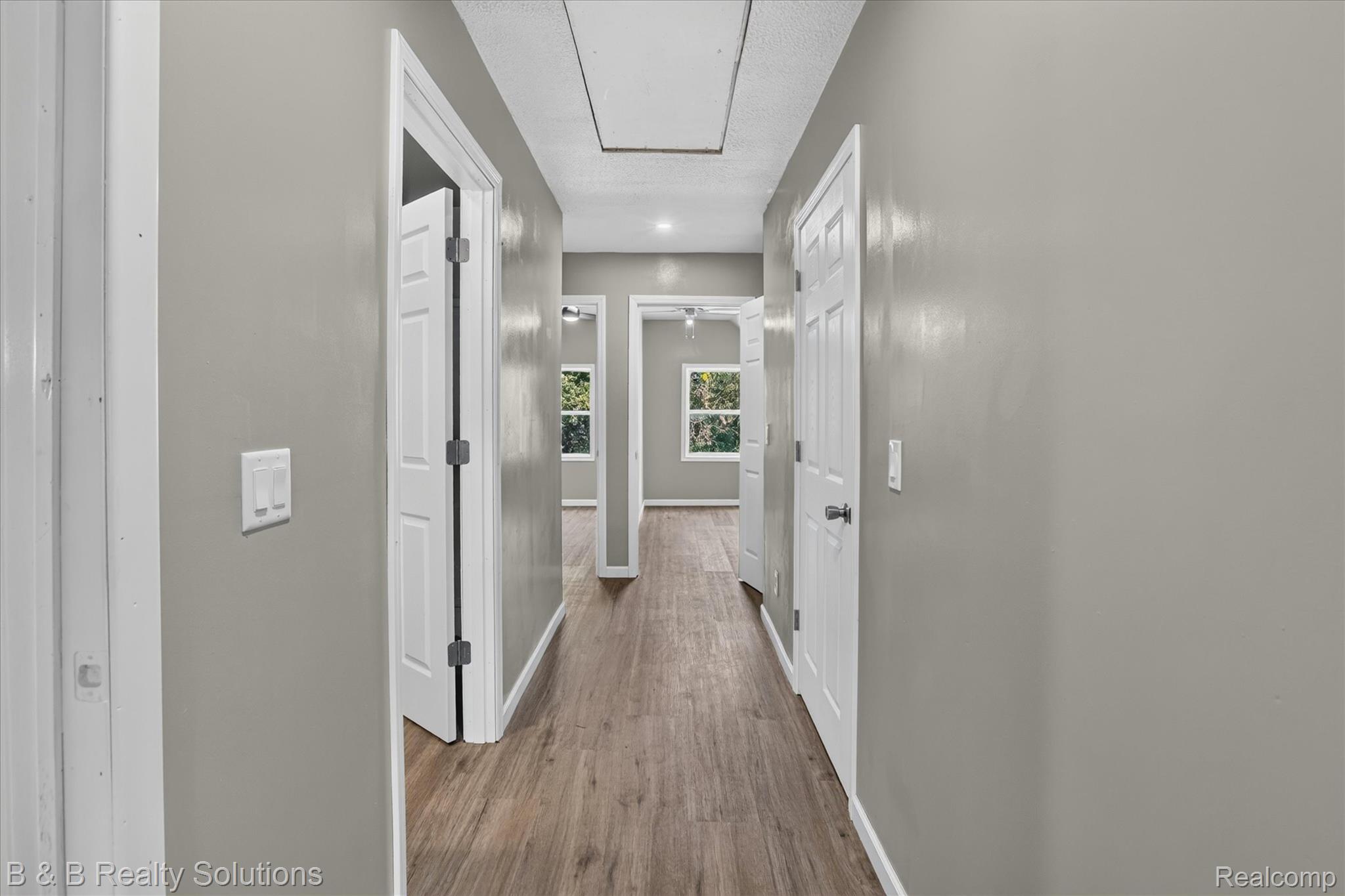 1564 East Burnside Road North Branch, MI 48461 - Photo 16 of 25 Hallway featuring wood-finish flooring, light gray wall paint, and white trim
