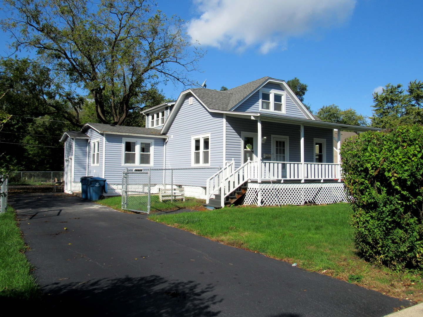 14446 Ridgeway Avenue Midlothian, IL 60445 - Photo 1 of 18 a front view of a house with a garden and porch