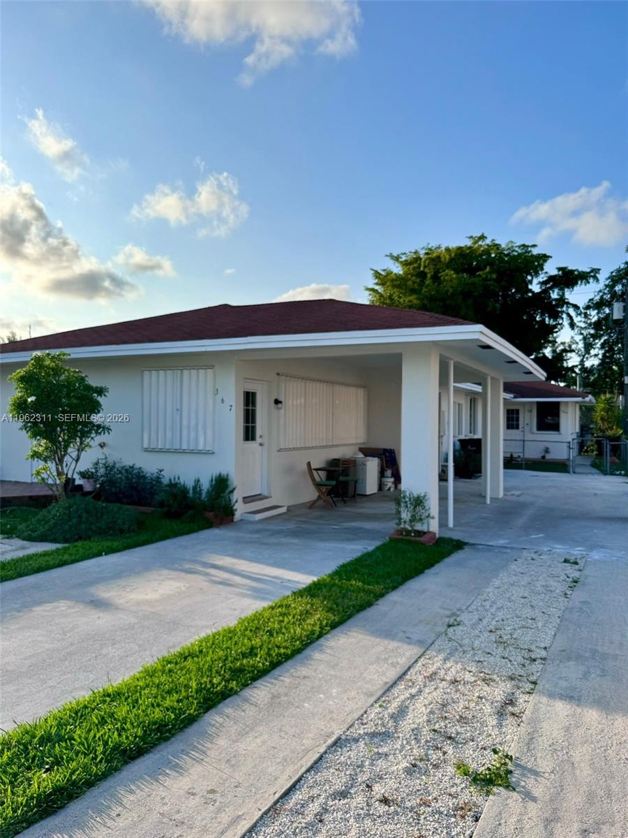 367 East 20th Street, Unit 369 Hialeah, FL 33010 - Photo 2 of 10 a front view of a house with a garden and trees