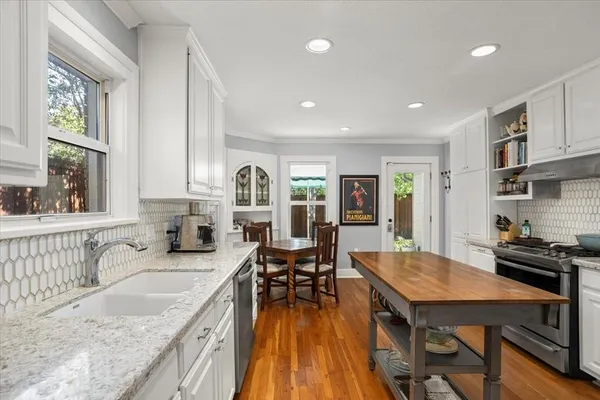 a kitchen with granite countertop a sink and wooden floor