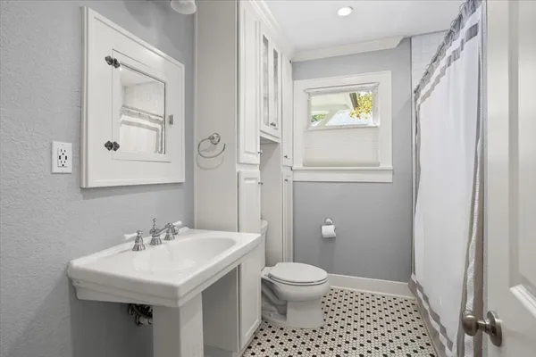 a bathroom with a sink a toilet and window