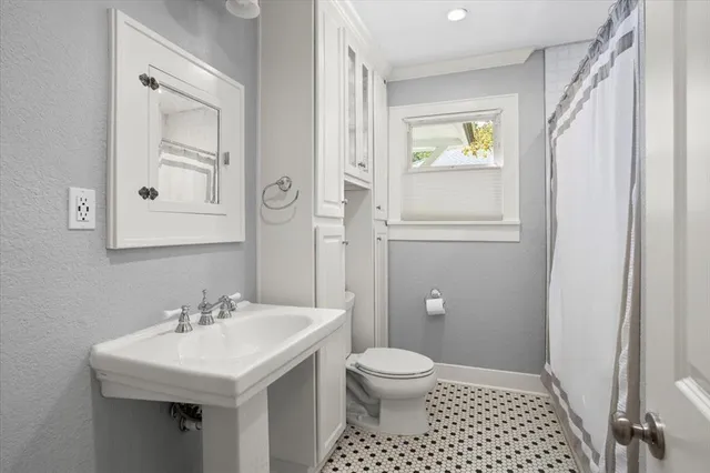 a bathroom with a sink a toilet and window