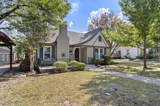 a front view of a house with a yard and potted plants