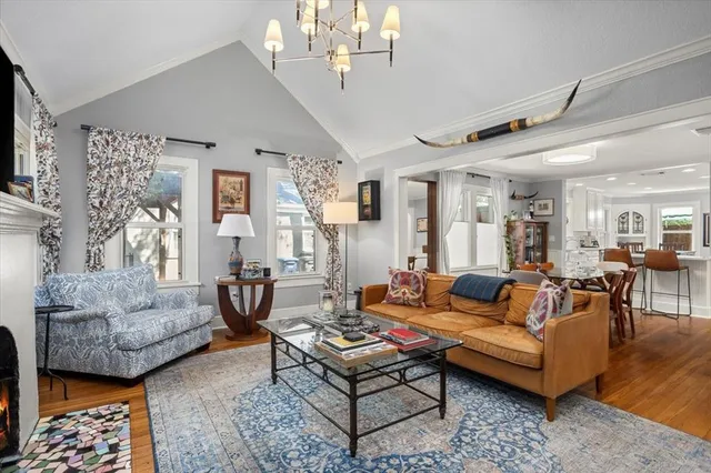 a living room with furniture a flat screen tv and a chandelier