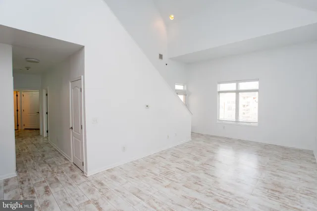 an empty room with wooden floor and window