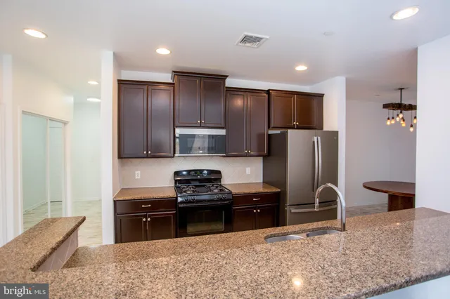 a kitchen with stainless steel appliances granite countertop a refrigerator stove and oven