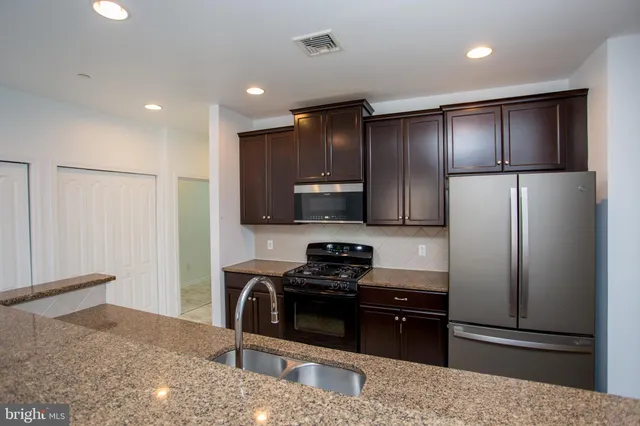 a kitchen with a refrigerator a microwave and wooden floor
