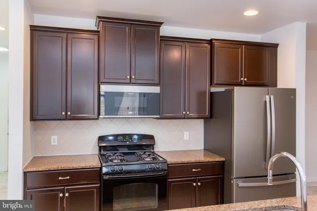 a kitchen with a refrigerator and a stove top oven
