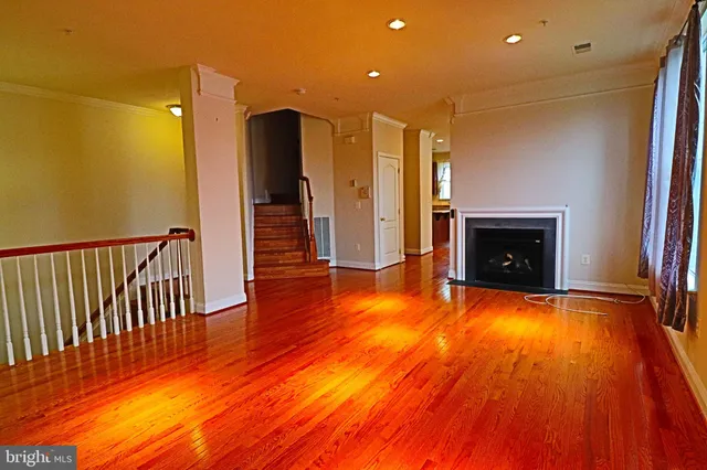 a view of a livingroom with wooden floor and a fireplace