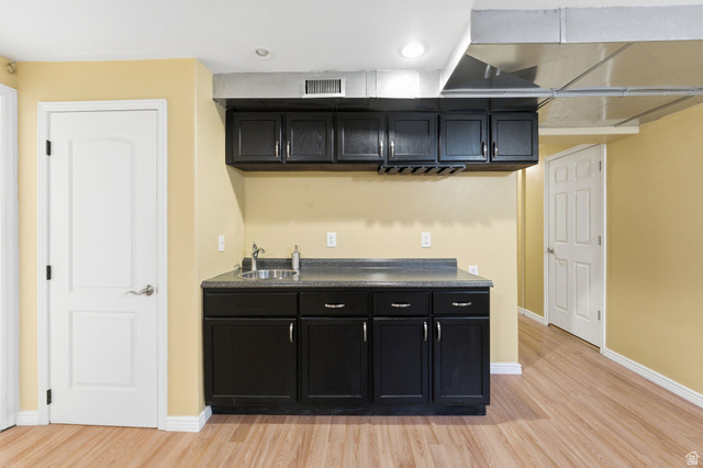 7235 Viansa Court Midvale, UT 84047 - Photo 31 of 43 Bar featuring dark cabinetry, light wood-style flooring, dark countertops, and recessed lighting