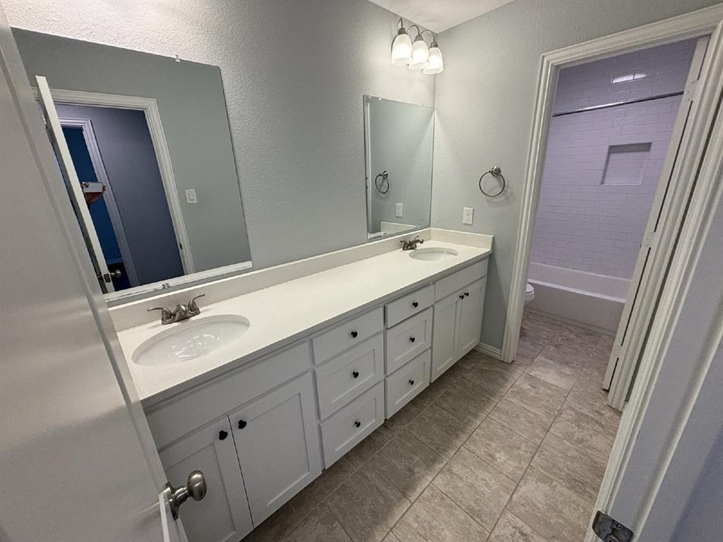 108 Arrowhead Street, Unit B Fort Worth, TX 76108 - Photo 13 of 17 a spacious bathroom with a double vanity sink a mirror and a shower