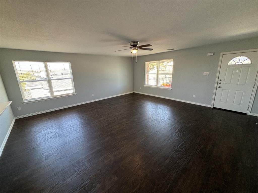 108 Arrowhead Street, Unit B Fort Worth, TX 76108 - Photo 4 of 17 an empty room with wooden floor and windows