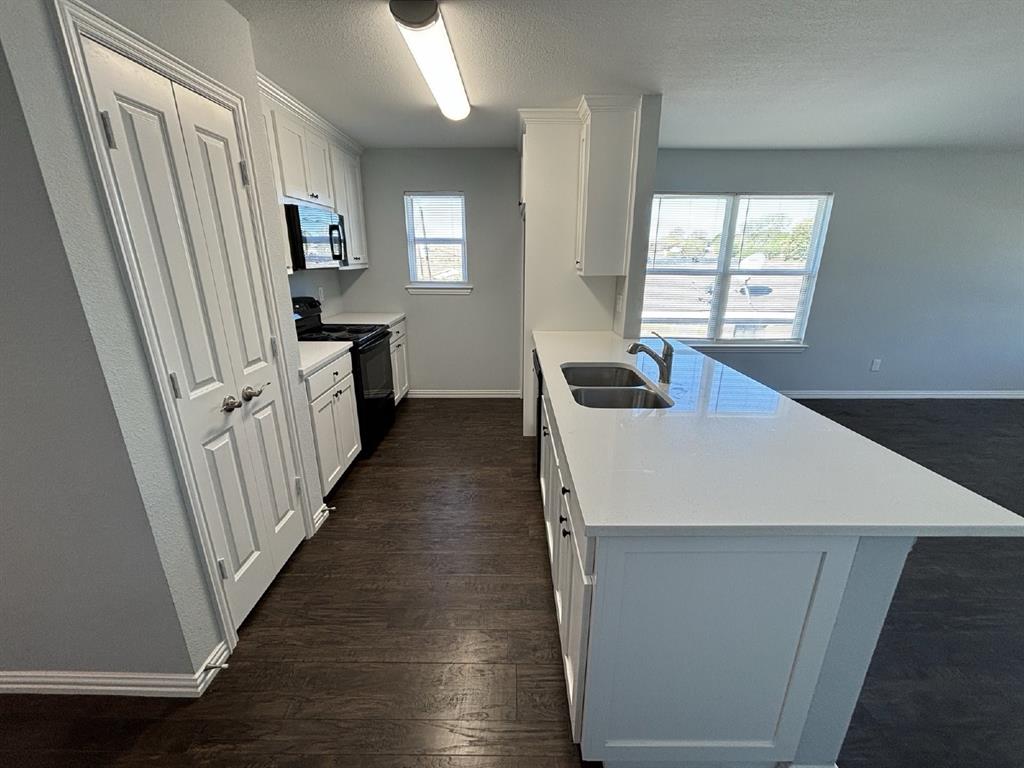 108 Arrowhead Street, Unit B Fort Worth, TX 76108 - Photo 6 of 17 a hallway with white cabinets and wooden floor
