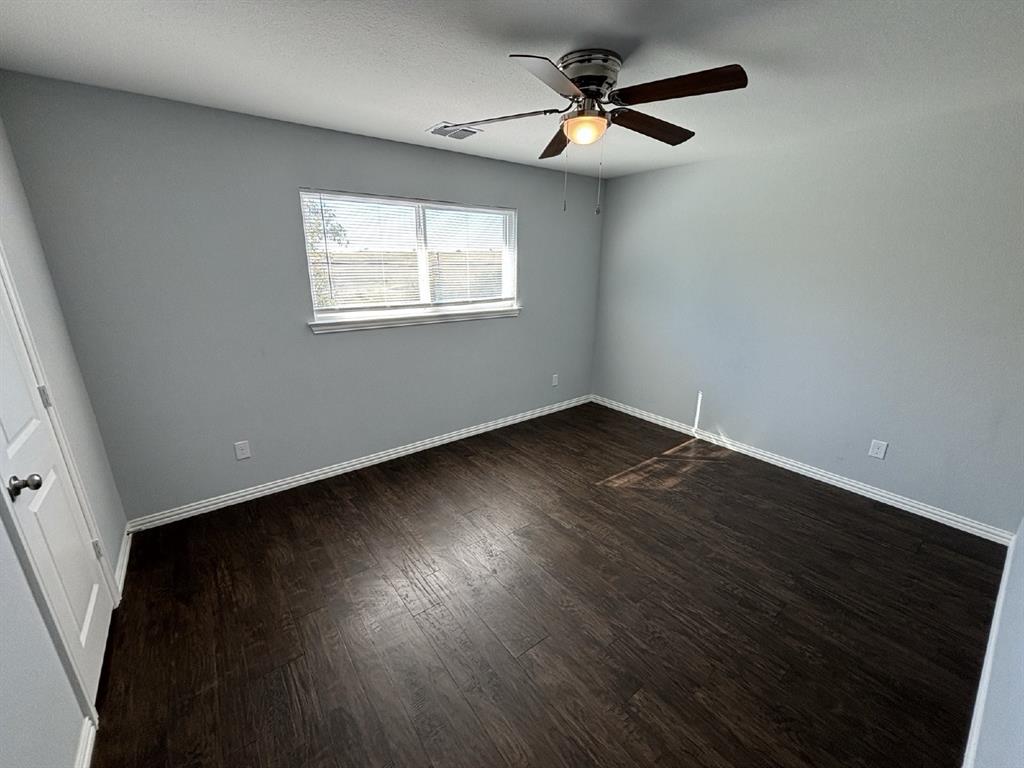 108 Arrowhead Street, Unit B Fort Worth, TX 76108 - Photo 10 of 17 a view of an empty room with wooden floor and a window