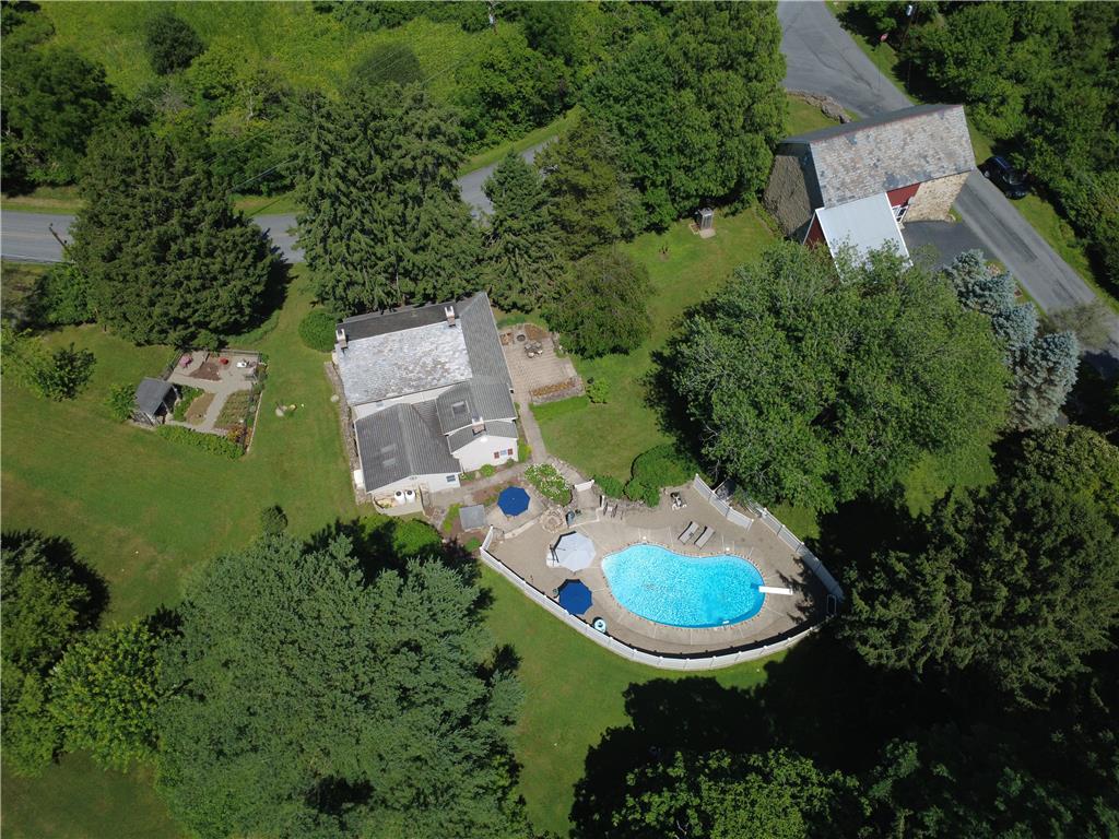 585 Buttermilk Road Hellertown, PA 18055 - Photo 82 of 82 An aerial perspective reveals a private pool oasis nestled within verdant grounds, alongside a charming stone barn.