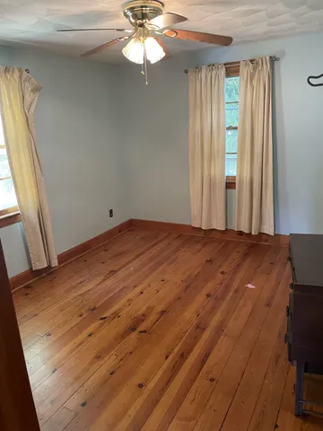 a view of a room with wooden floor and windows