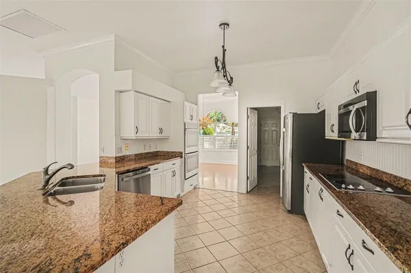 a kitchen with stainless steel appliances granite countertop a sink stove and refrigerator