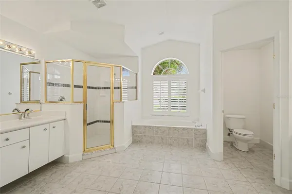 a spacious bathroom with a granite countertop sink a toilet and a window