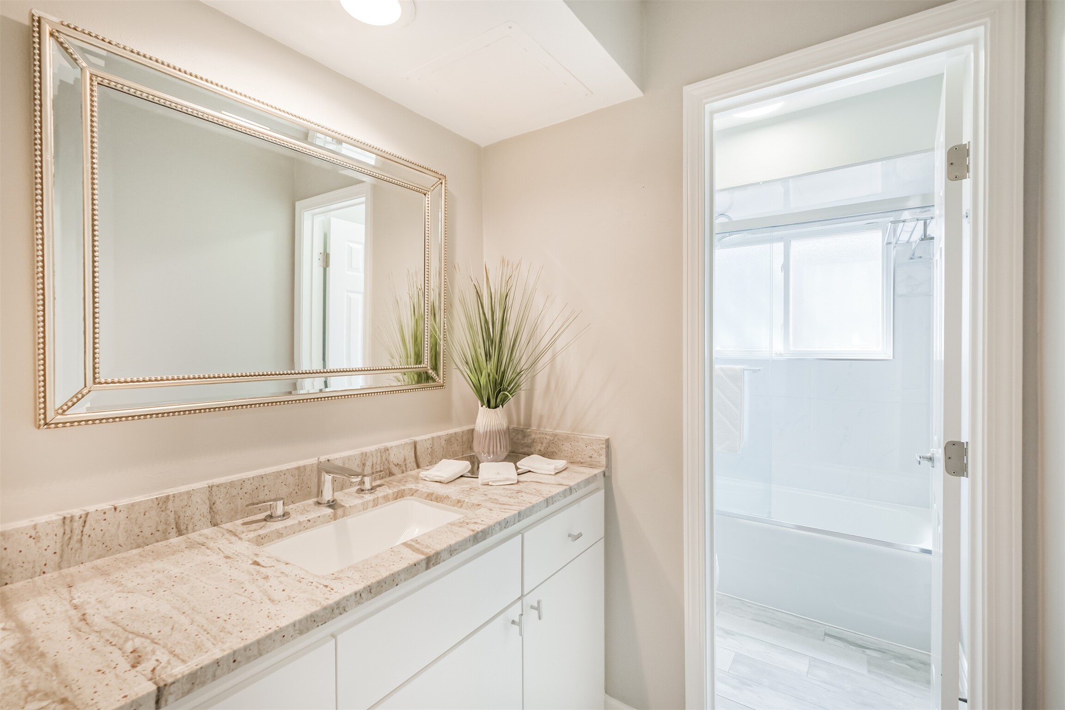 1007 Arrow Hill Road Houston, TX 77077 - Photo 32 of 48 The second full bathroom is shared between the second and third bedroom. It has been updated with tile wood floors, granite counters, a framed mirror, tub+shower duo with tile surround and sliding glass door.