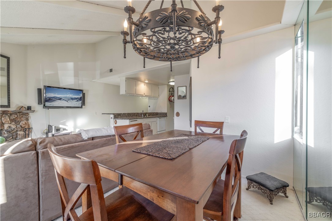 760 Blue Jay Road, Unit 34 Big Bear Lake, CA 92315 - Photo 7 of 24 a view of a dining room with furniture a chandelier and wooden floor