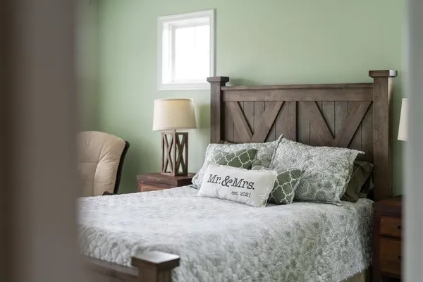 a large bed sitting in a bedroom next to a window