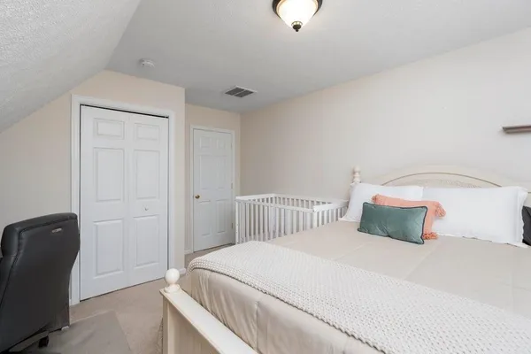 a bedroom with a bed and a chair