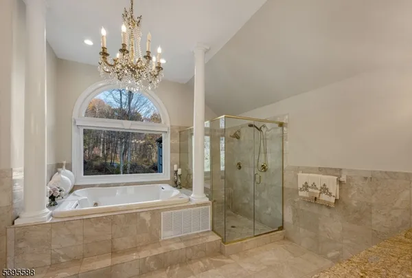 a spacious bathroom with a granite countertop tub shower and mirror