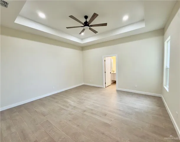 an empty room with ceiling fan and window
