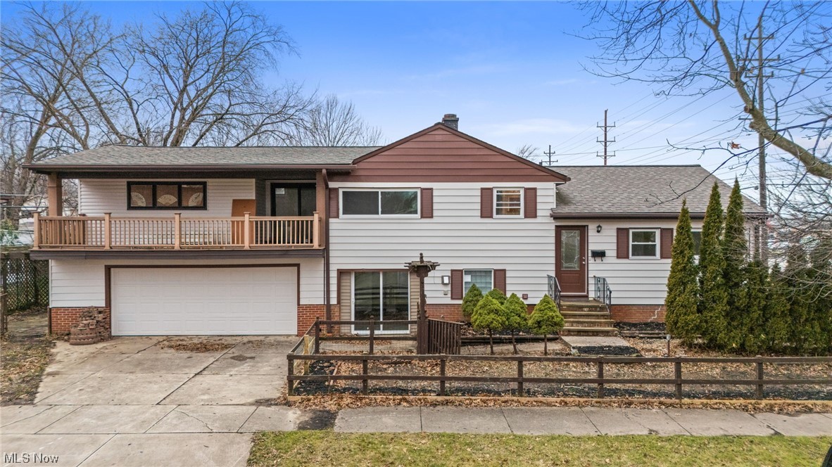 View of front of house with a garage and a balcony