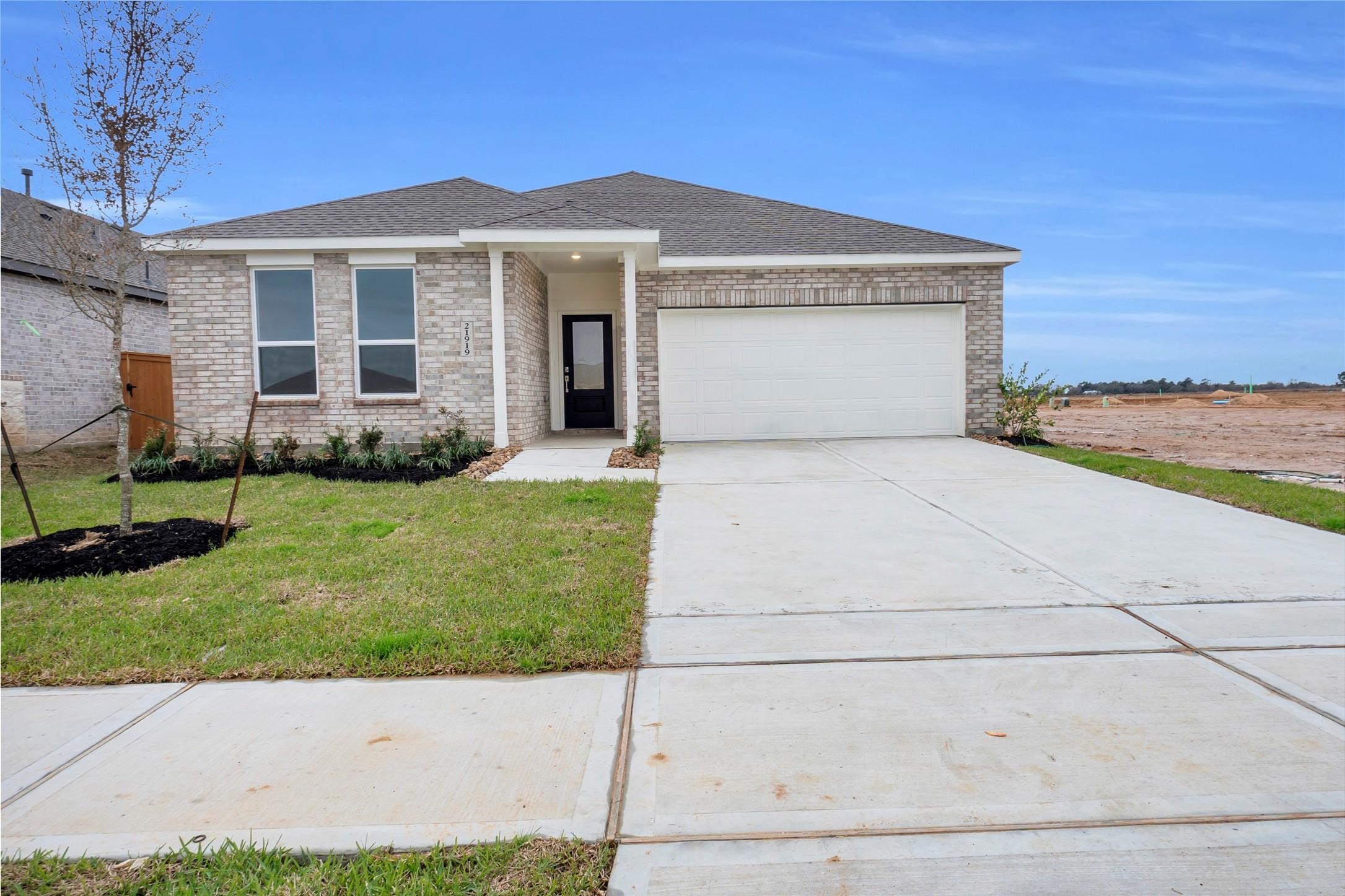 213 Orchard Cove Snook, TX 77879 - Photo 1 of 16 a front view of a house with a garden and yard