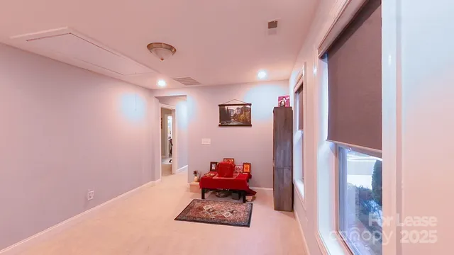 a hallway with painting on the wall and a large window