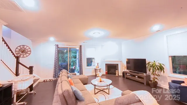 a living room with furniture a flat screen tv and a floor to ceiling window