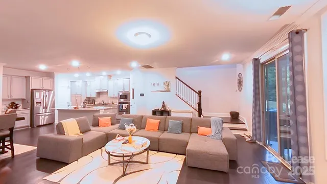 a living room with furniture kitchen view and a chandelier