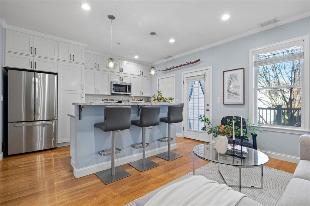 242 West Fifth Street, Unit 3 Boston, MA 02127 - Photo 13 of 37 a kitchen with kitchen island a stove a table and chairs in it