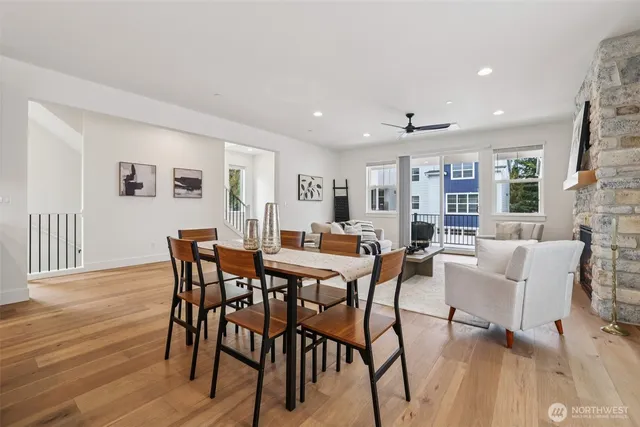 a view of a dining room and livingroom with furniture wooden floor a rug a flat screen tv a painting and a chandelier