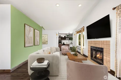 an empty room with wooden floor fireplace and windows