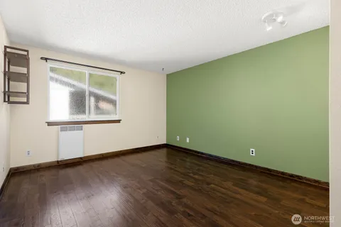 a view of empty room with wooden floor