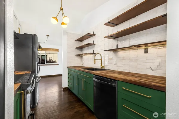 a kitchen with stainless steel appliances granite countertop a sink and a refrigerator