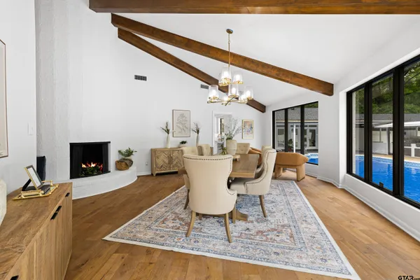 a dining room with furniture a fireplace and wooden floor