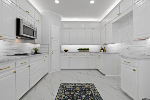 a kitchen with granite countertop white cabinets and white appliances