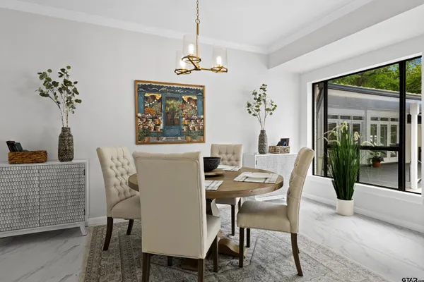 a dining room with furniture potted plants and wooden floor